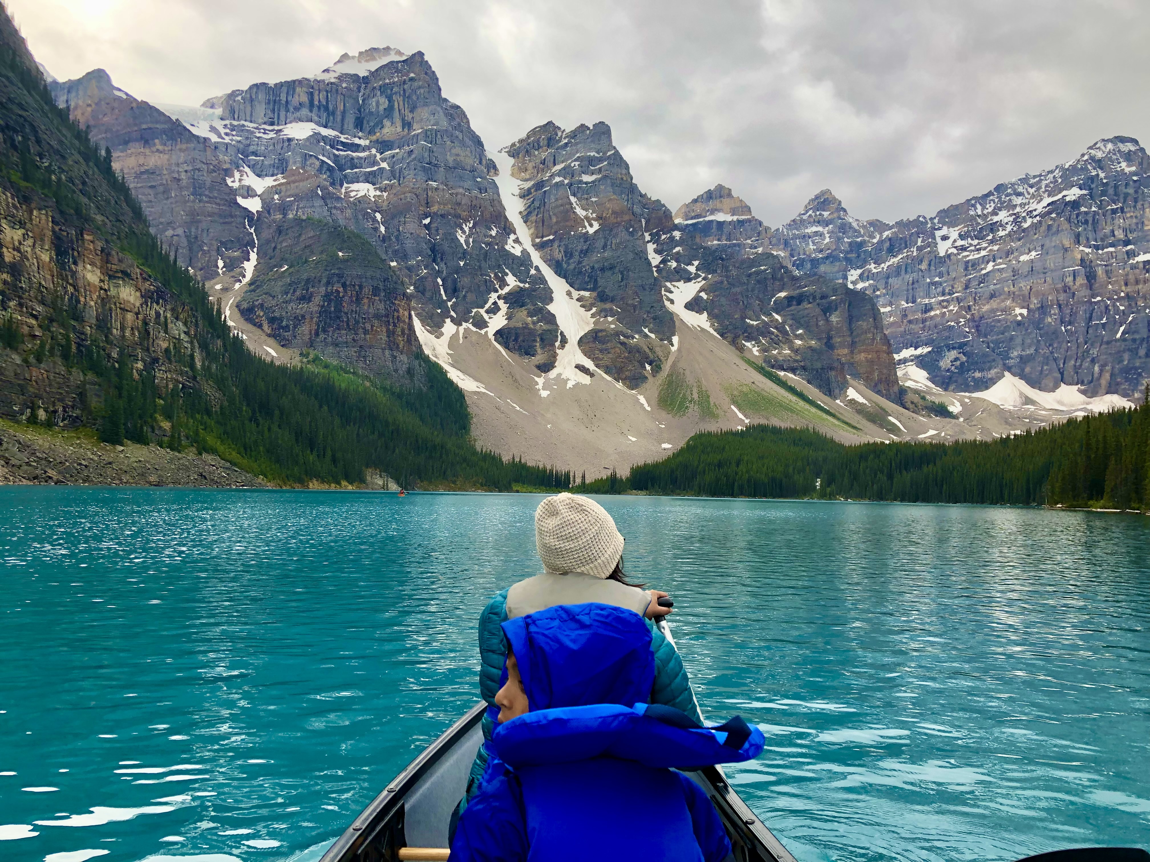Canoeing on a turquoise lake with mountain peaks